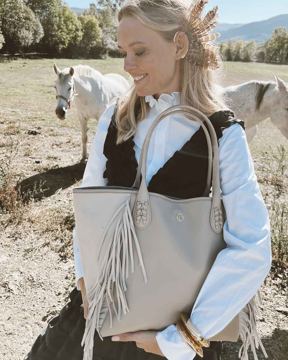 Femme blonde avec un sac à main beige à franges