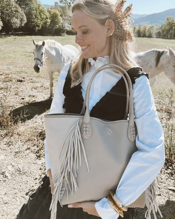 Femme blonde avec un sac à main beige à franges